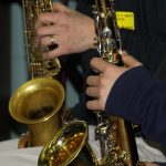 A detail of two saxophone players' instruments and hands